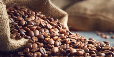 Roasted coffee beans spilling from a hessian sack