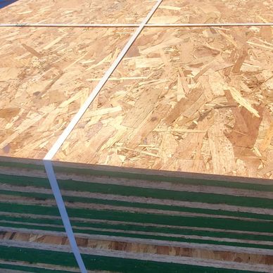 Stacked plywood sheets secured with white straps.