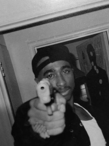 Tupac pointing a gun