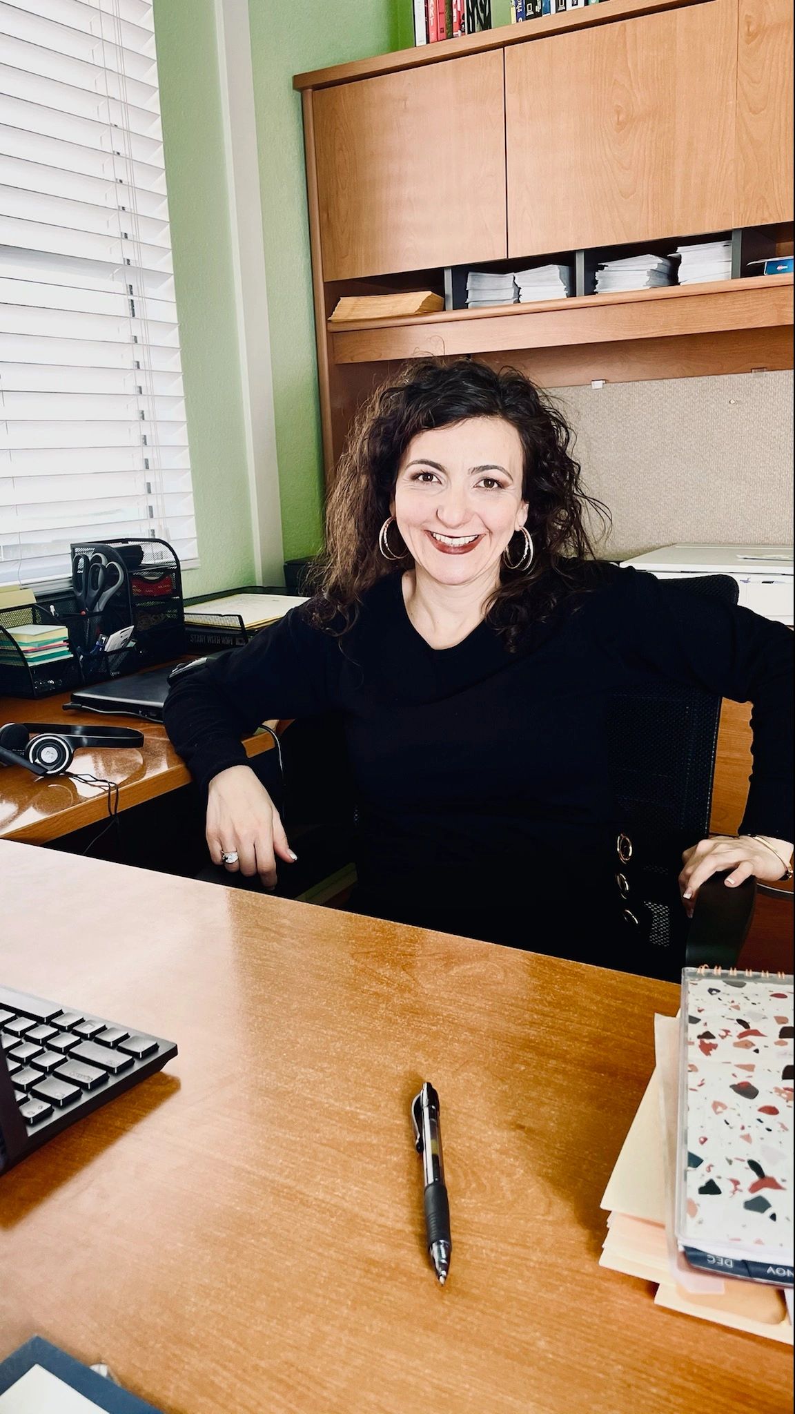 Ruzanna Hernandez sitting in her home office, creator of efficiencyandorganization.com