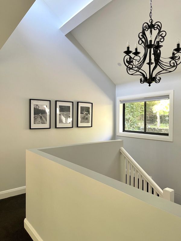 Staircase with tall ceiling and chandelier by CT Built
