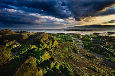 Paysage de l'ile-aux-Coudres avec vue sur le fleuve.  Beau coucher du soleil avec un ciel dramatique.