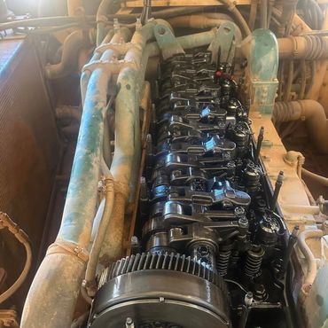 Close-up of an engine's rocker arm assembly with visible gears and pipes.