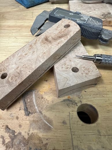 Wood pieces with holes and measurement tools on a workbench.