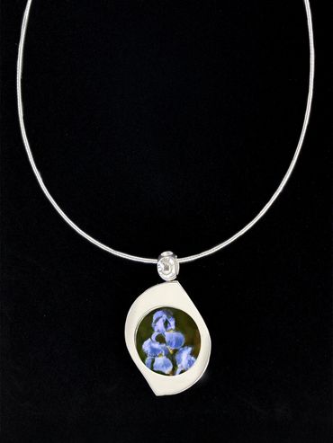 silver pendant with image of purple iris inserted