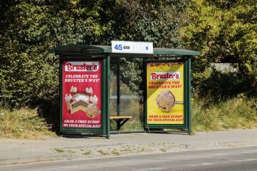 Bus stop with Bruster's ice cream ads offering free scoops on special days by Kindall Wright - KX Graphic Design.