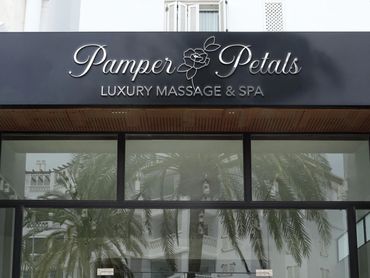 Black signboard of Pamper Petals Luxury Massage & Spa by Kindall Wright - KX Graphic Design.