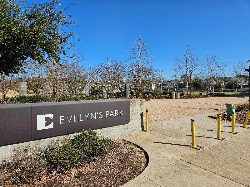 Evelyn's Park in Bellaire, Texas. A sign with trees and a park in the background. 