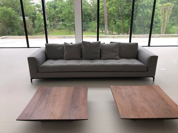 A high-end gray couch sofa in front of a large glass wall.