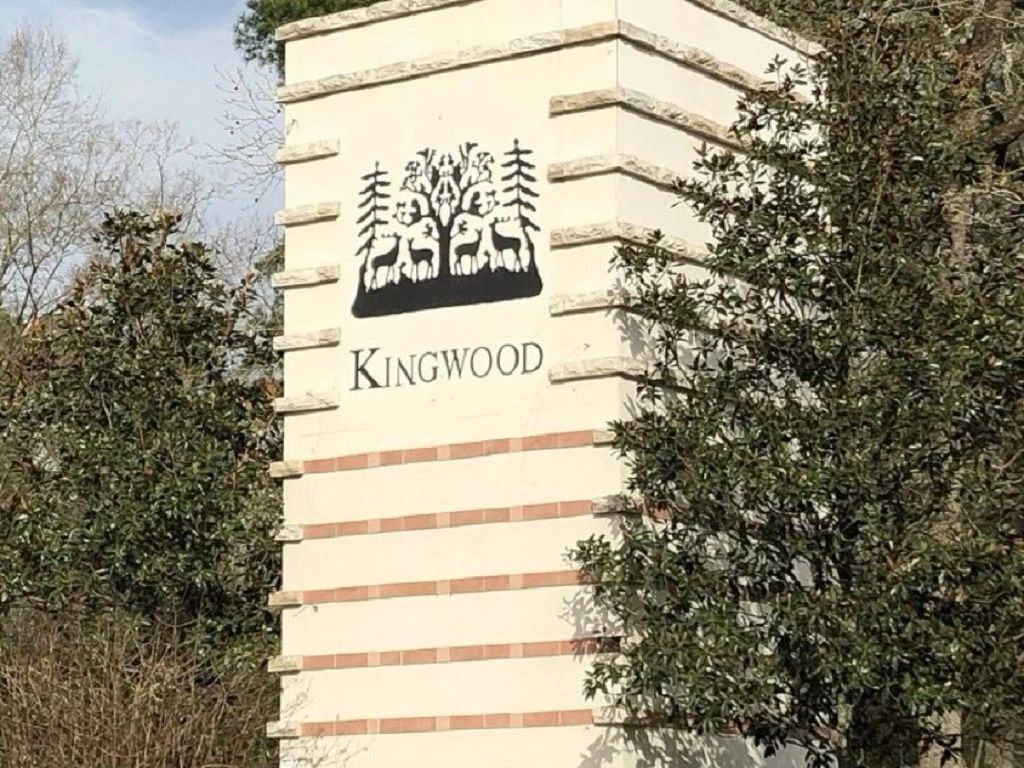 Kingwood entrance sign with trees surrounding it.
