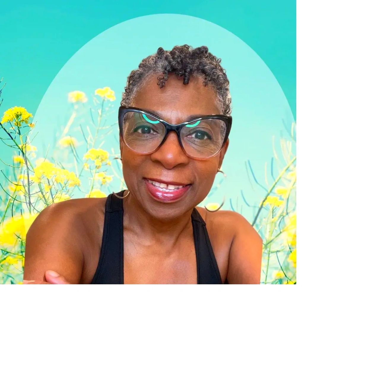 Smiling woman with short curly hair and glasses against a floral background.