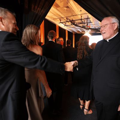 Man shaking smiling priest's hand