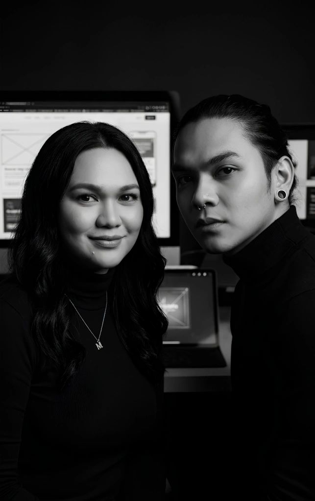 Black and white portrait of two young adults with computer screens behind them.