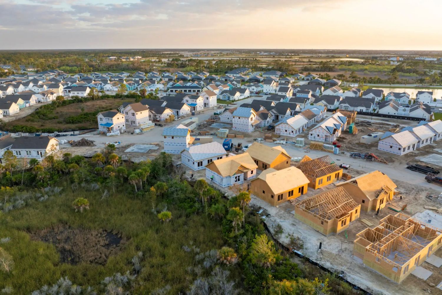 Aerial view of a suburban housing development under construction at sunset.