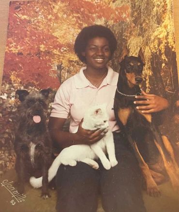 Woman posing with three dogs.