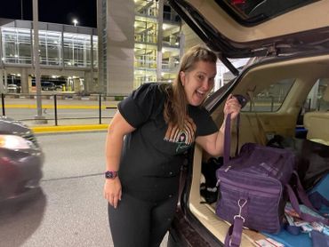 Woman loading pet into vehicle.