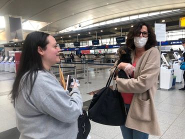 Women at airport with dog.