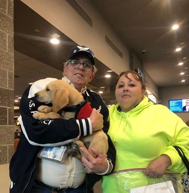 Couple holding golden retriever puppy.