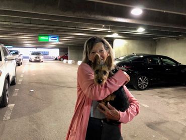 Woman hugging dog in garage.