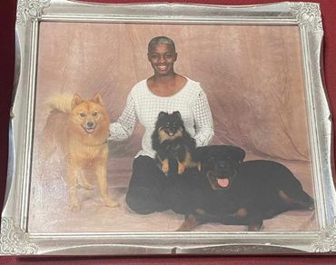 Woman sitting with several dogs.