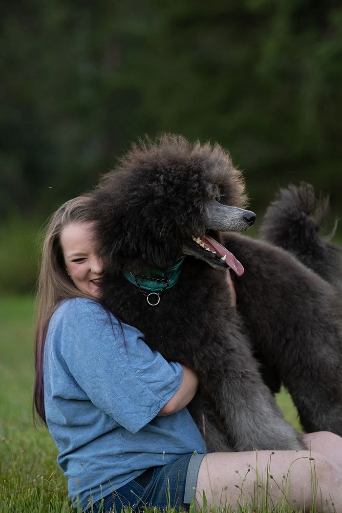 Laughing woman hugging fluffy dog
