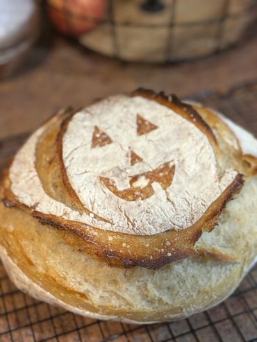A loaf of bread with a jack-o'-lantern face scored on top.