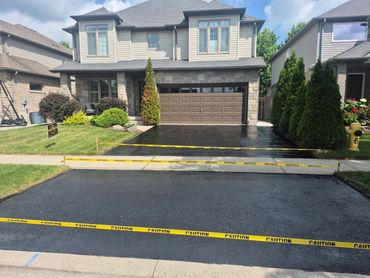 Newly paved driveway with caution tape.