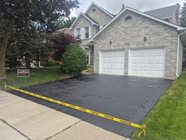 Freshly paved driveway with caution tape around it.