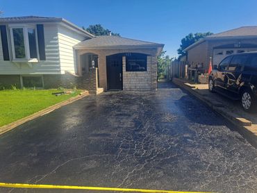 Residential driveway after professional asphalt sealing
