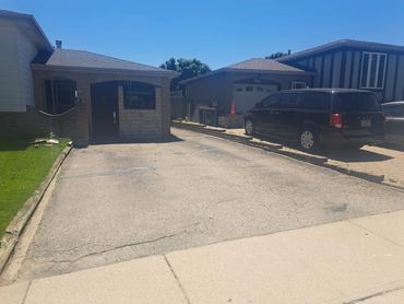 Faded asphalt driveway before professional sealing