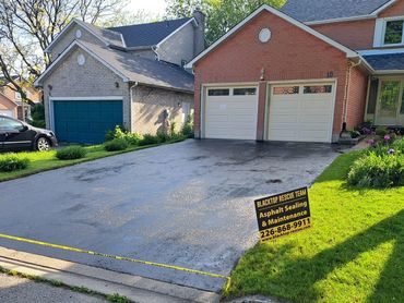 Freshly sealed driveway in a residential area.