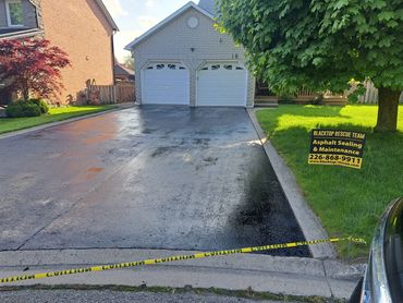 Restored asphalt driveway with a clean sealed finish