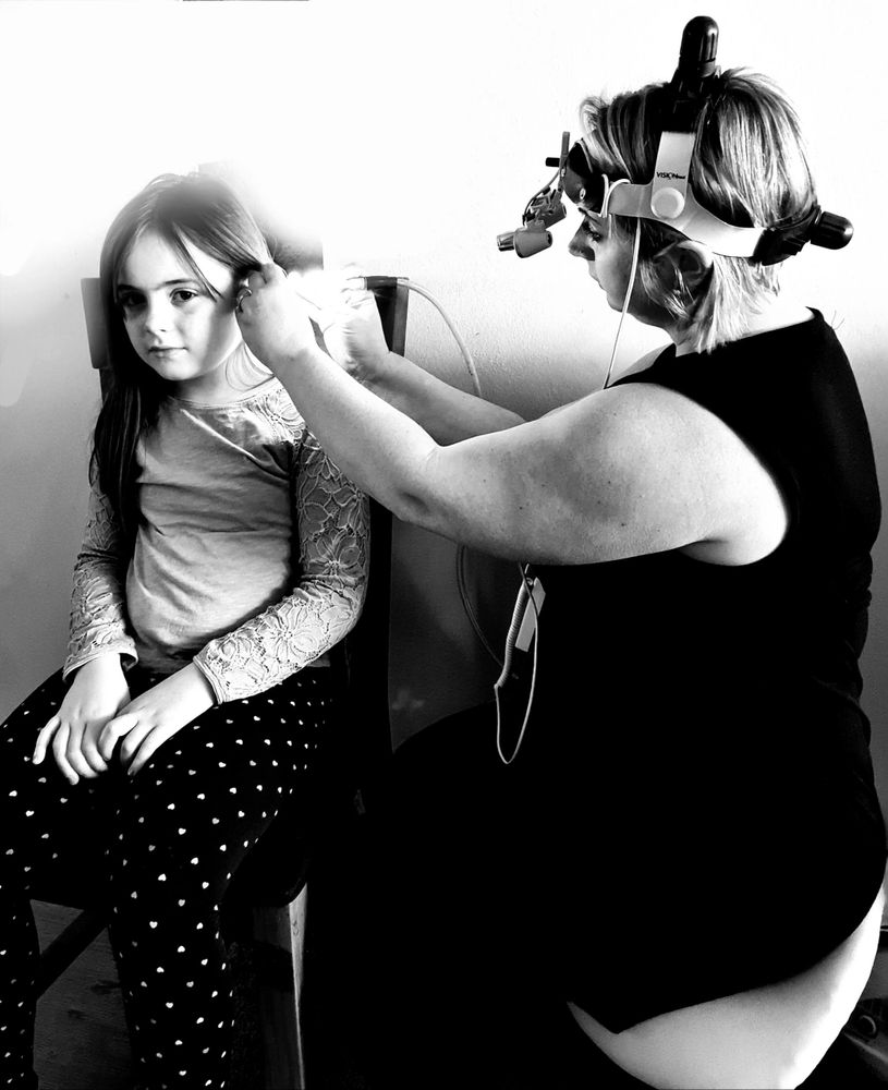 Doctor checking the ear of a little girl