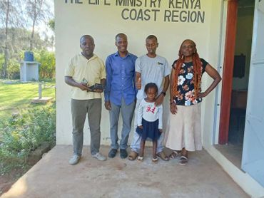 A group of five people standing outside a building labeled The Life Ministry Kenya Coast Region.