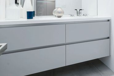 Modern bath/vanity fitted with custom cabinets clad in Matte Silverlake by Rehau.