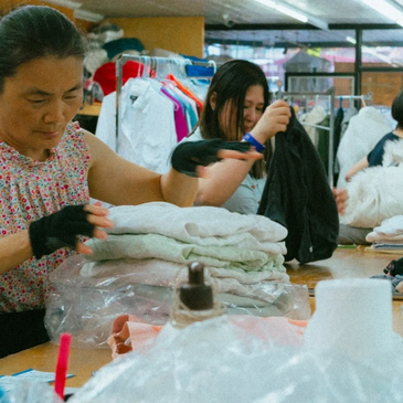 "Montague Cleaners staff folding fresh laundry at a worktable for same-day wash and fold service"