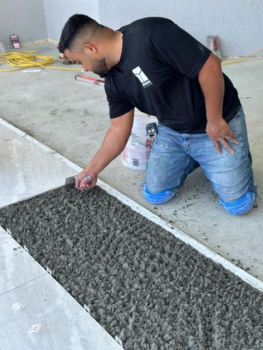 Benignis tiles team member working on the floor tiles