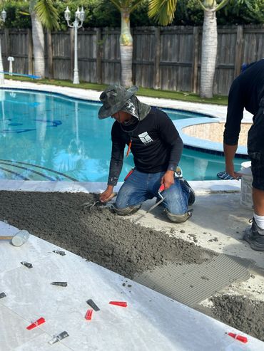 benignistiles team member working on the floor near to the pool