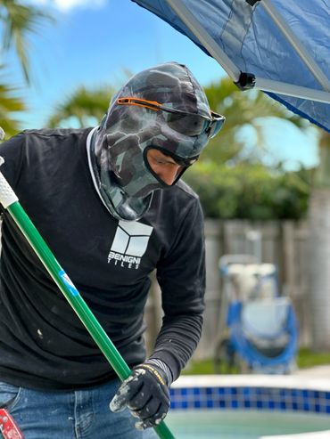 Benignis tiles team member working near the pool with facemask