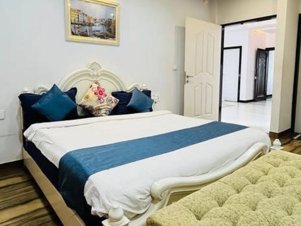 Cozy bedroom with white bed and blue accents.
