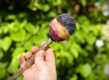 Swirling green, purple and green felted wool on a beater head. Main image with blurred background