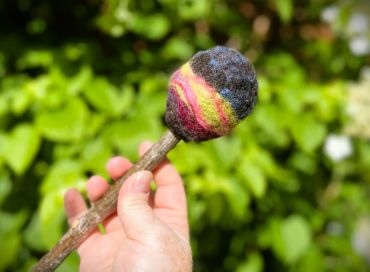Swirling green, purple and green felted wool on a beater head. Main image with blurred background