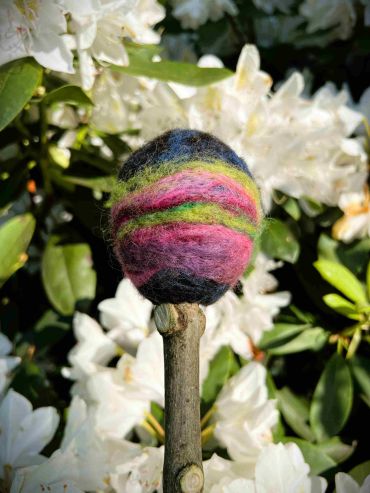 Close up image of the swirling coloured felt on the drum beater reflecting the colours of aurora