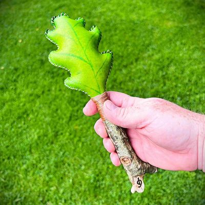 A green dyed hand rattle designed to look like an Oak leaf.