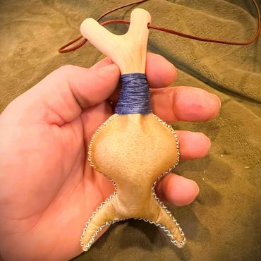 The rear of the Horned God Neck Rattle showing shape, stitching, wrap and Oak peg.