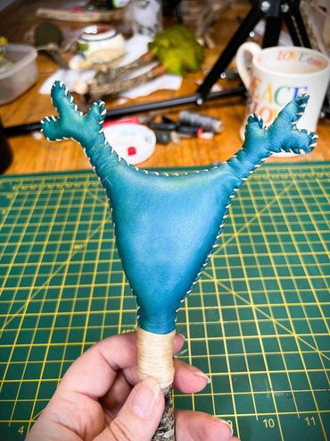 Making stage of Cernunnos Rattle. Green rattle head in front of cutting mat.