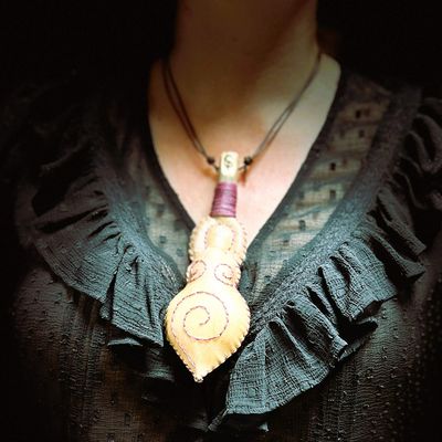 Ruth wearing a goddess rattle with purple stitching