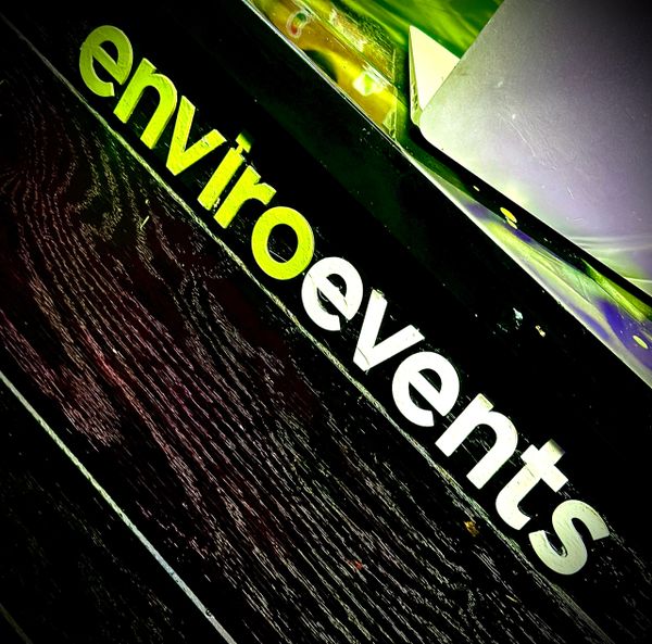 Sign with the words 'enviroevents' in green and white text on a black surface.