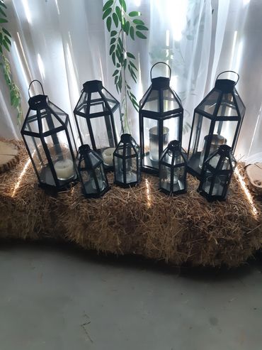 8 Black metal and glass candle lanterns. 4 large and 4 medium.