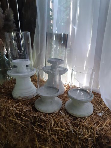 4 White and glass candle holders, 2 large and 2 medium.